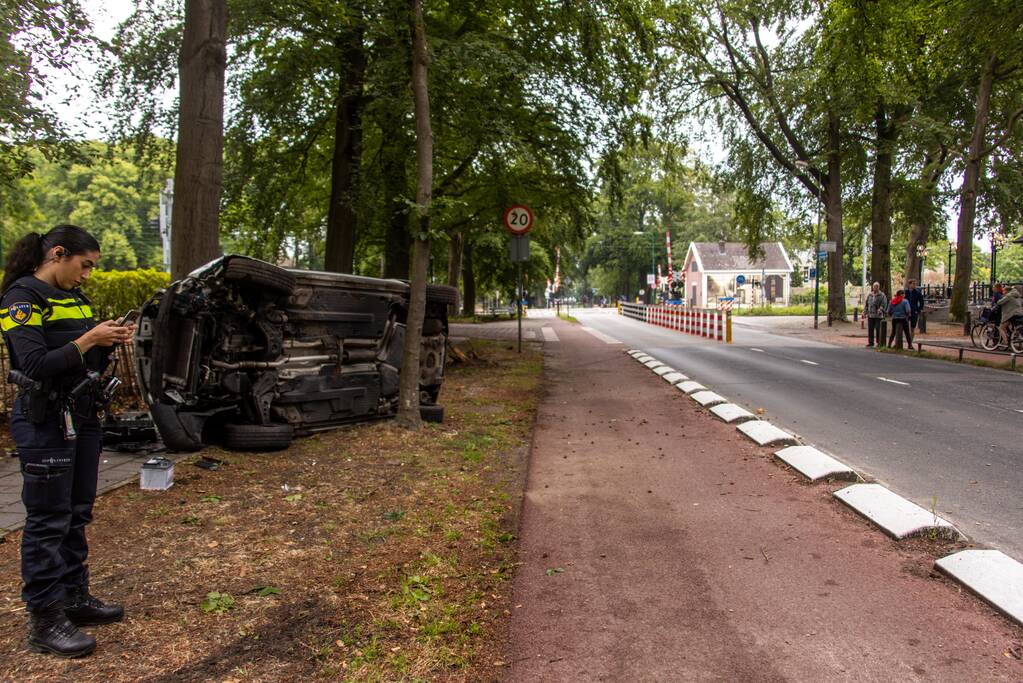 Auto crasht belandt op zijkant, bestuurder slaat op de vlucht