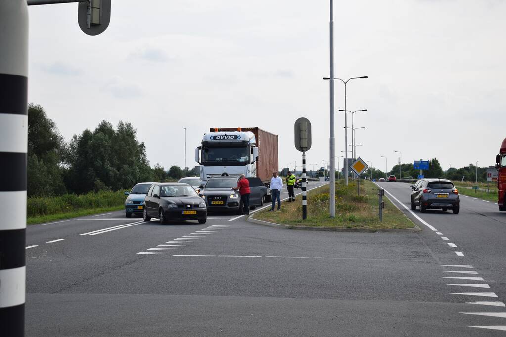 Vrachtwagen botst achterop personenauto voor stoplichten