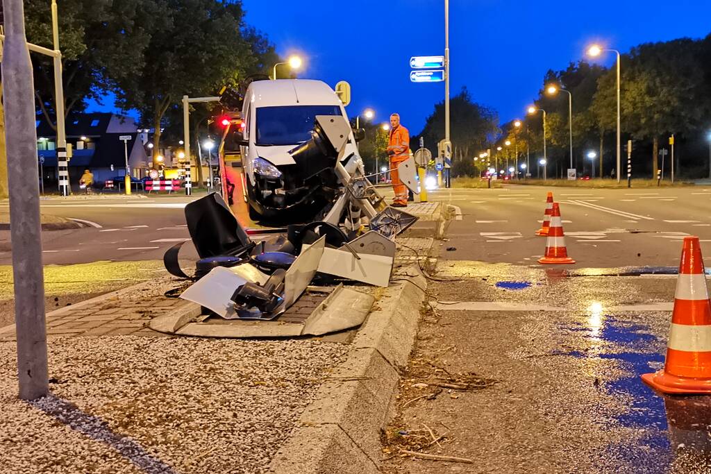 Bestelbus rijdt verkeerslicht uit de grond