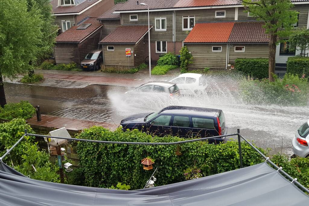 Straat onder water na wolkbreuk