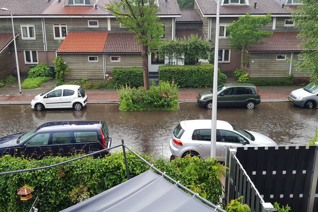 Straat onder water na wolkbreuk