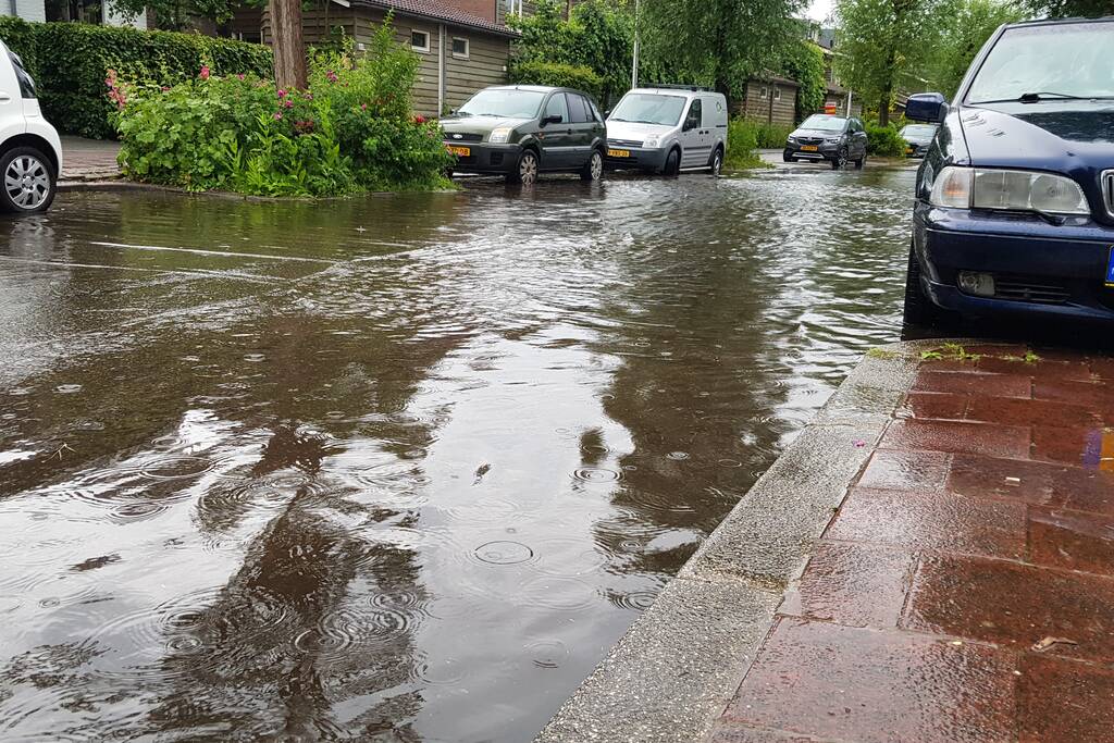 Straat onder water na wolkbreuk