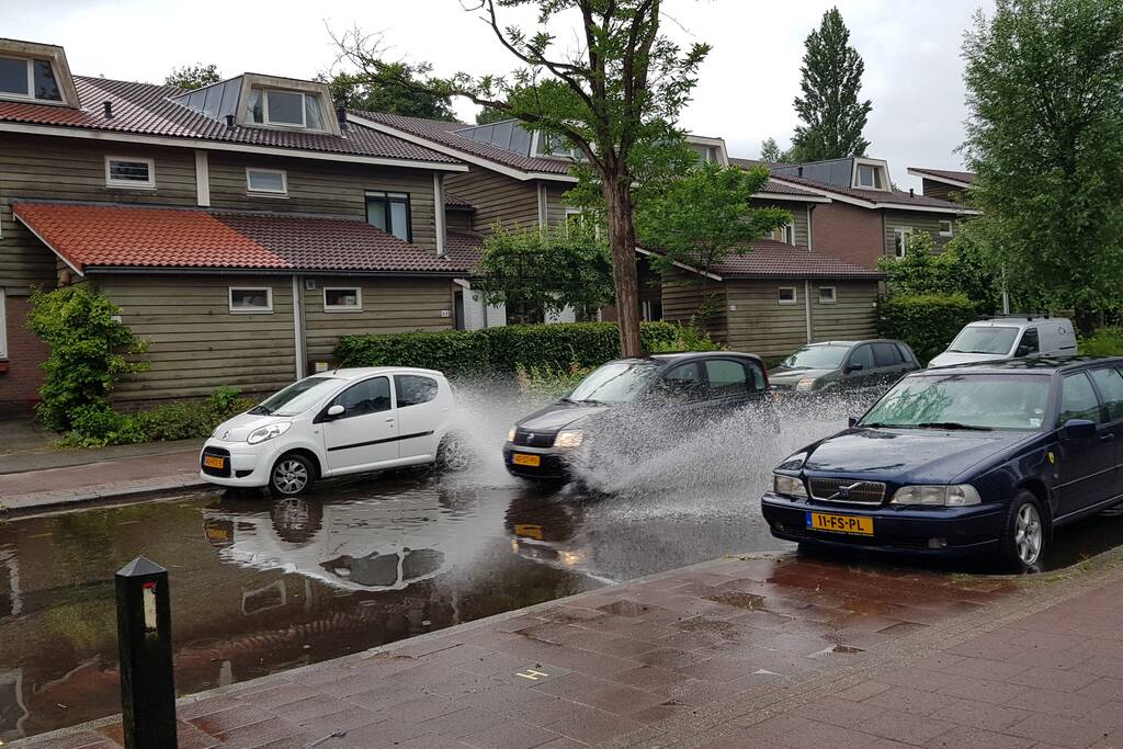 Straat onder water na wolkbreuk