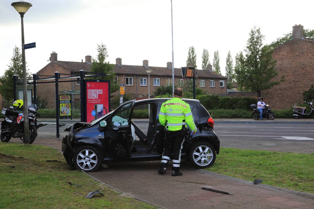 Auto vliegt uit de bocht en knalt op verkeerslicht
