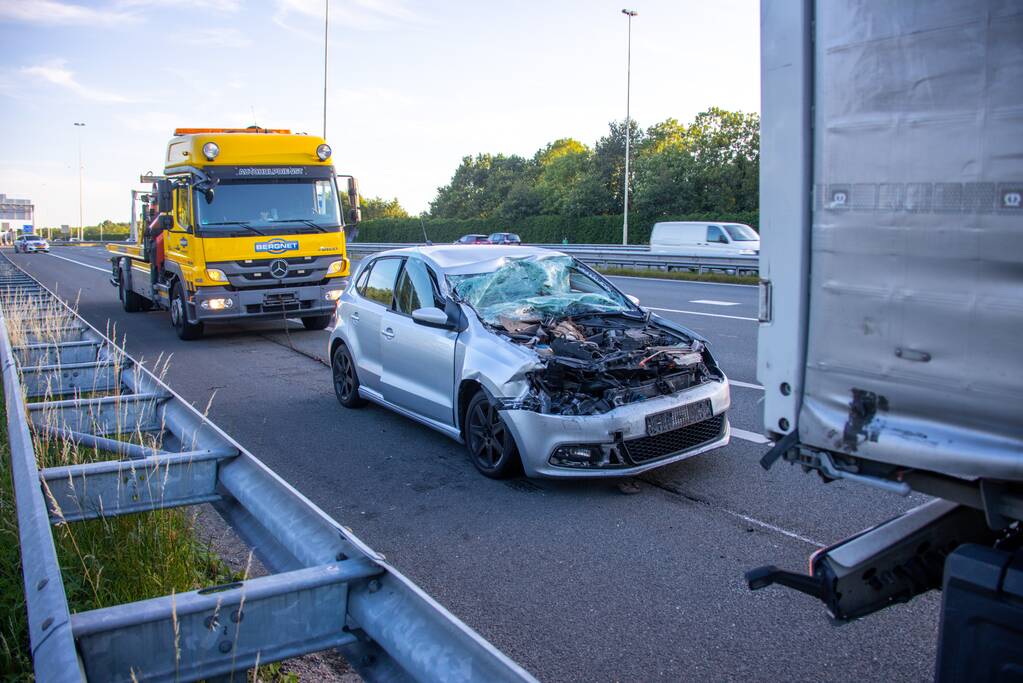 Auto schiet onder oplegger vrachtwagen