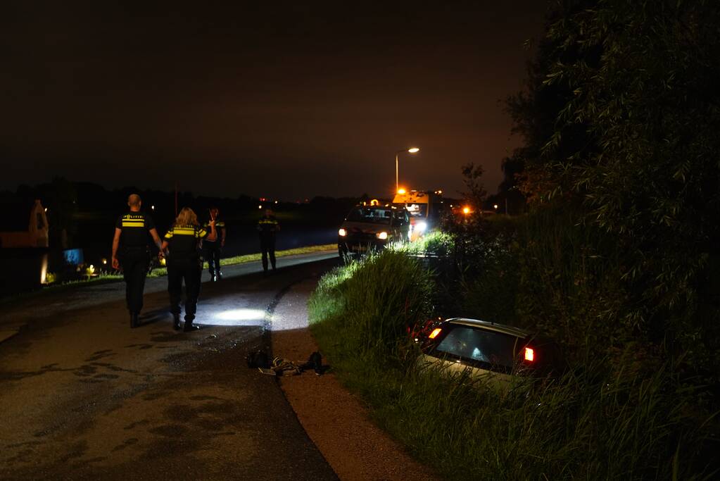 Auto te water na missen van bocht