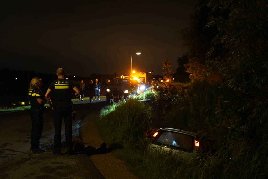 Auto te water na missen van bocht