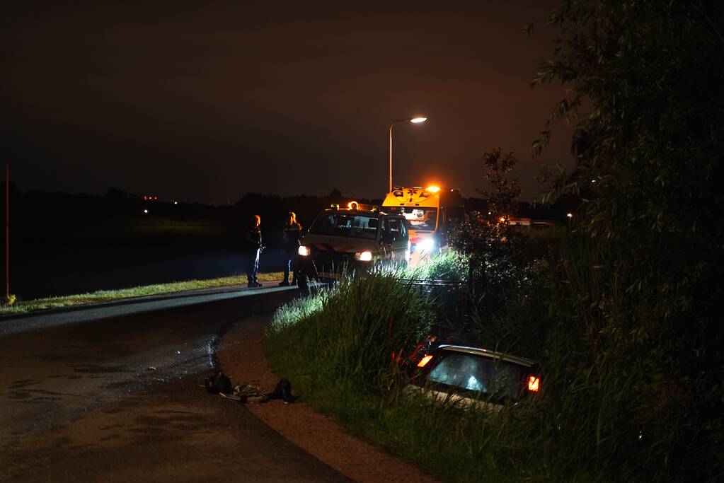 Auto te water na missen van bocht