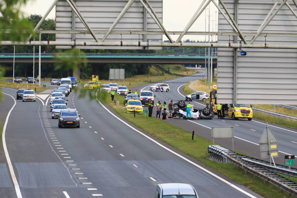 Auto op de kop na aanrijding op snelweg