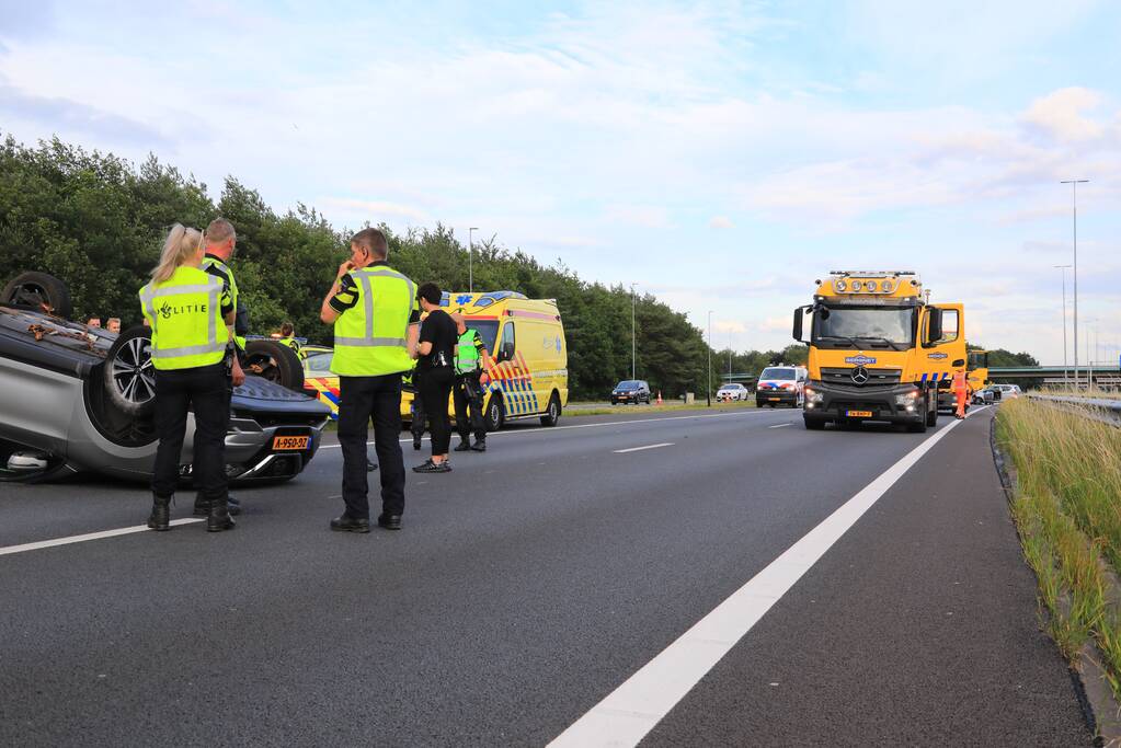 Auto op de kop na aanrijding op snelweg