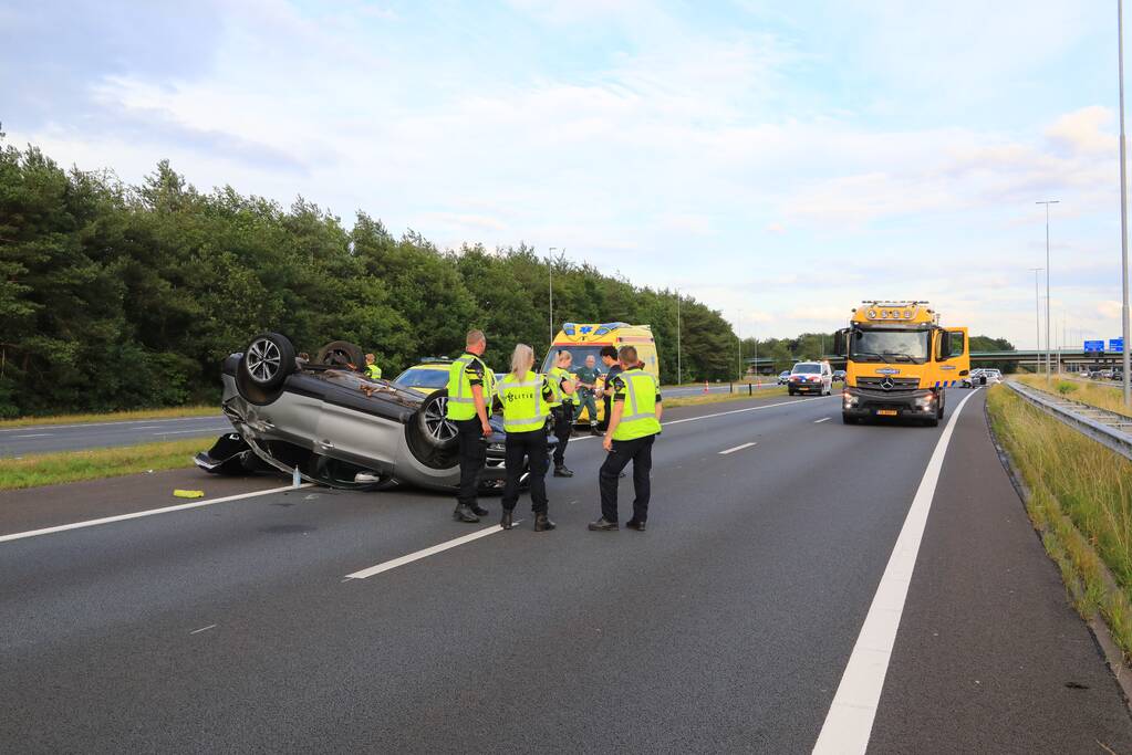 Auto op de kop na aanrijding op snelweg