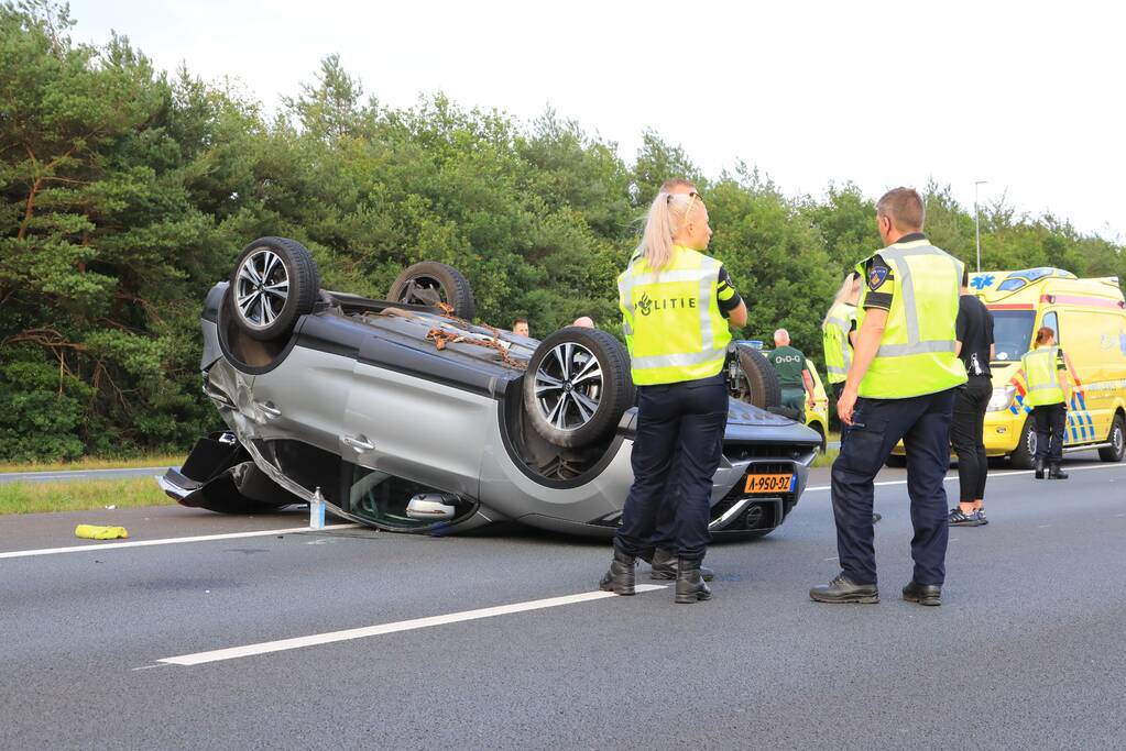 Auto op de kop na aanrijding op snelweg