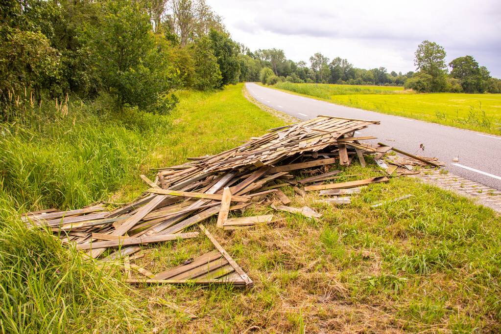 Oude schutting langs de weg gedumpt