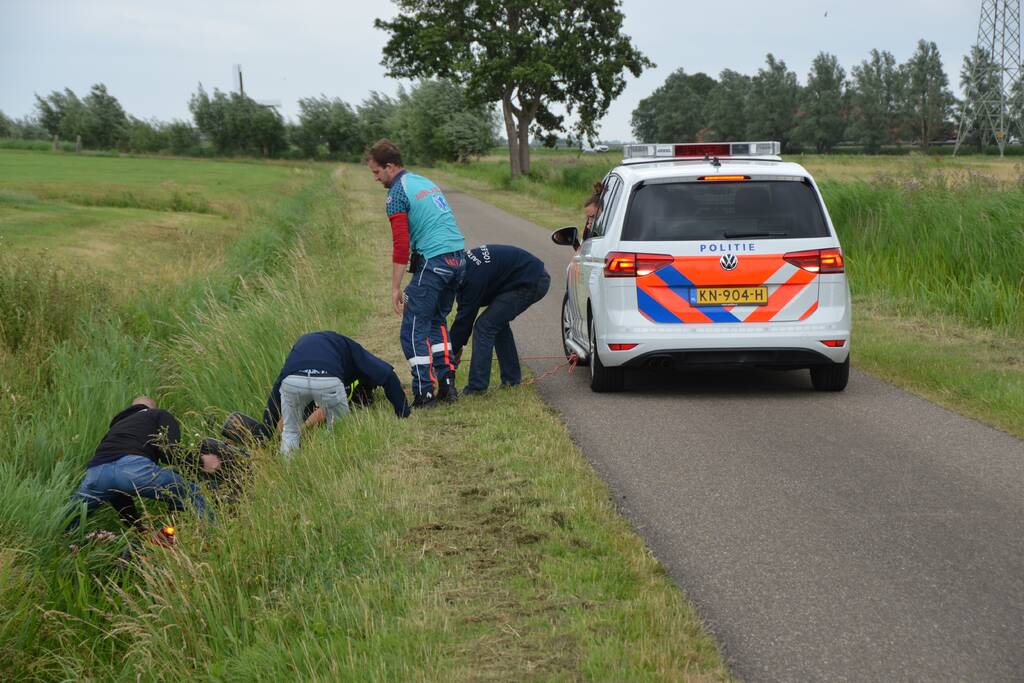 Omstanders halen scootmobiel uit greppel
