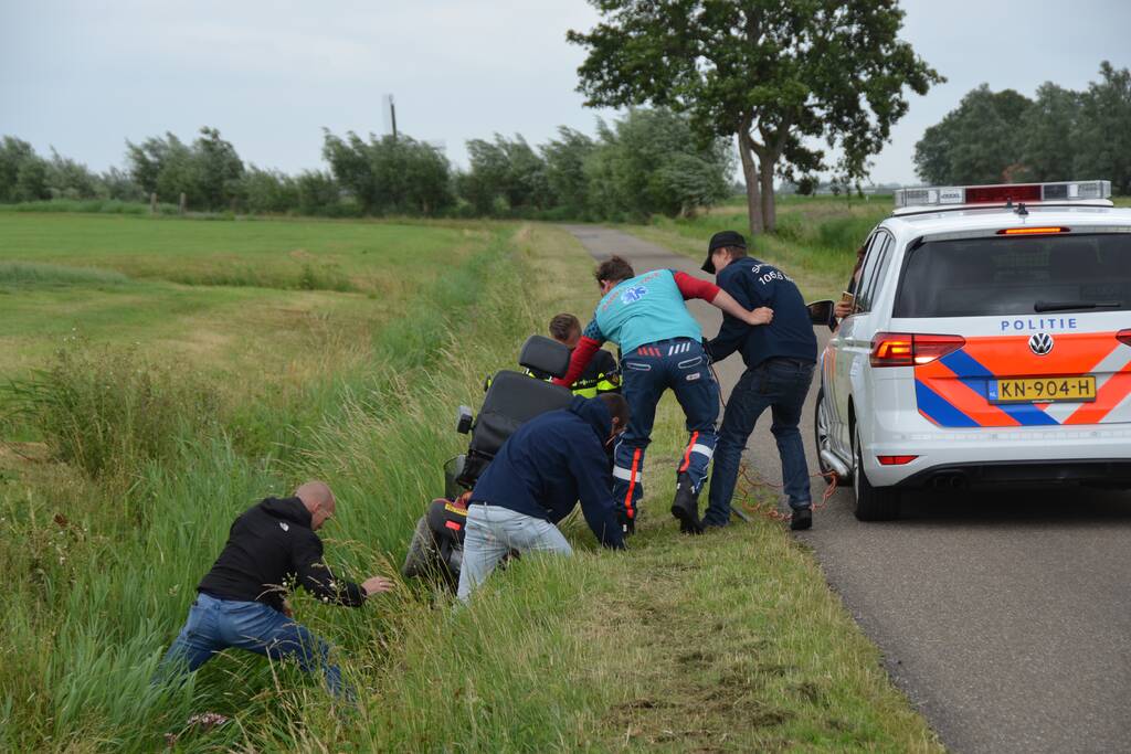 Omstanders halen scootmobiel uit greppel