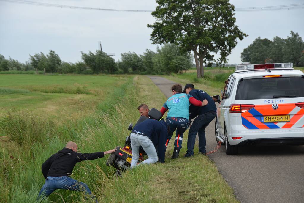 Omstanders halen scootmobiel uit greppel