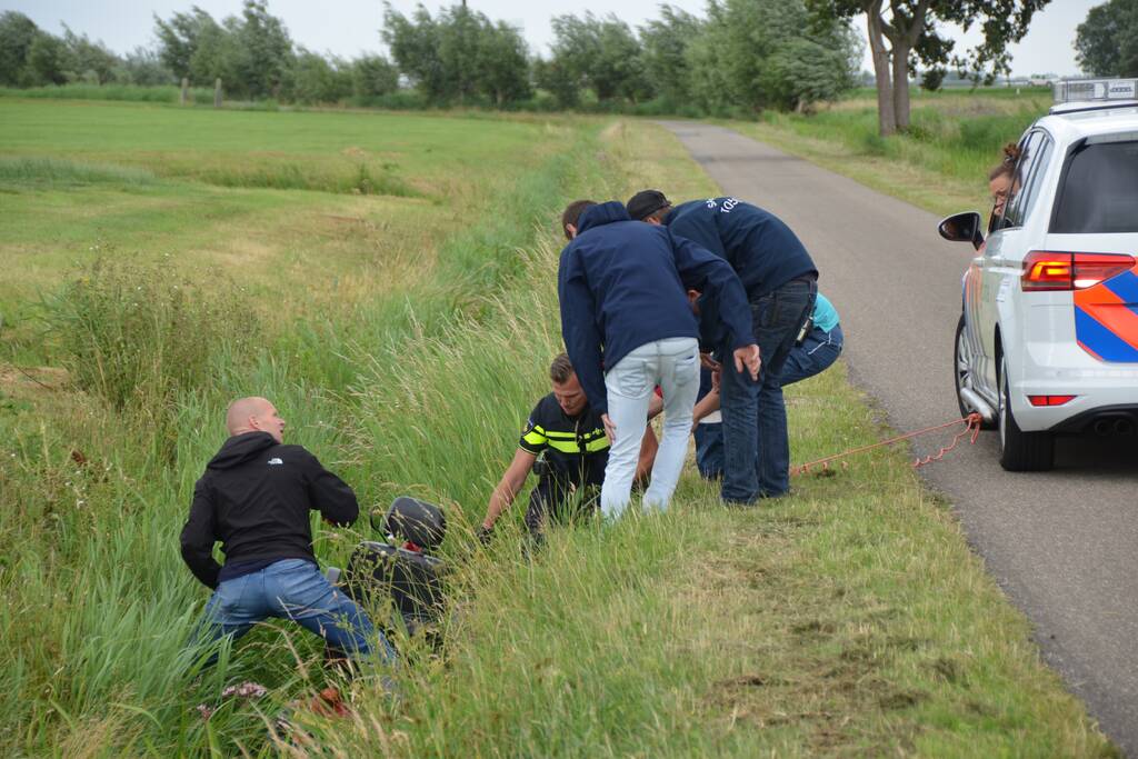 Omstanders halen scootmobiel uit greppel