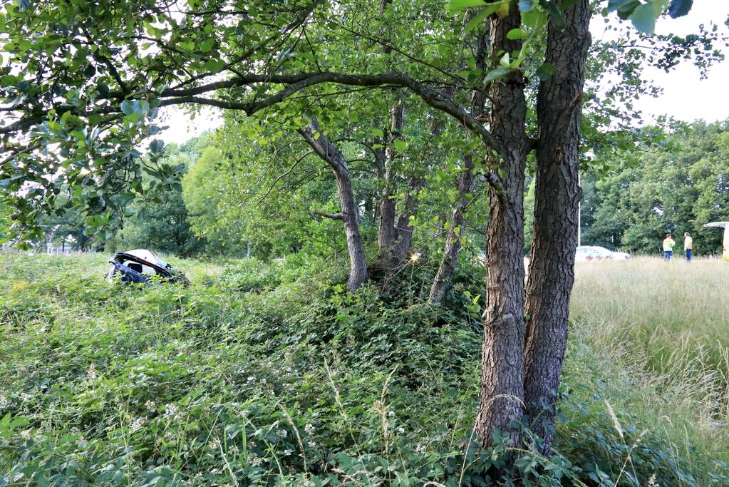 Auto crasht tussen bomen door