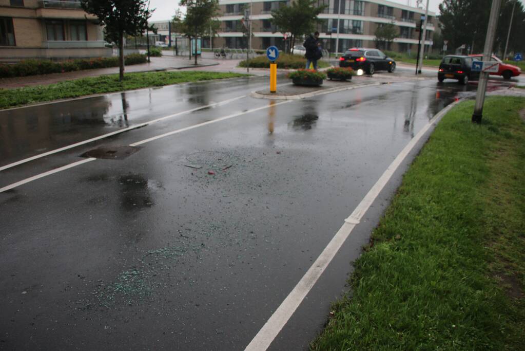 Boodschappenbus klapt achterop auto voor rotonde