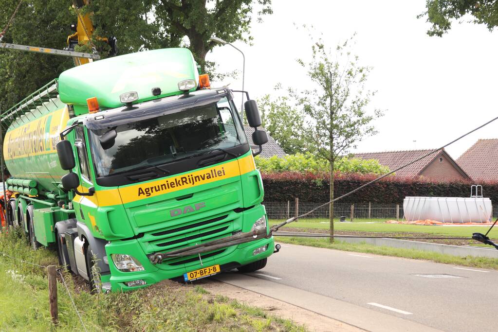 Vrachtwagen met bulkoplegger zakt weg in berm