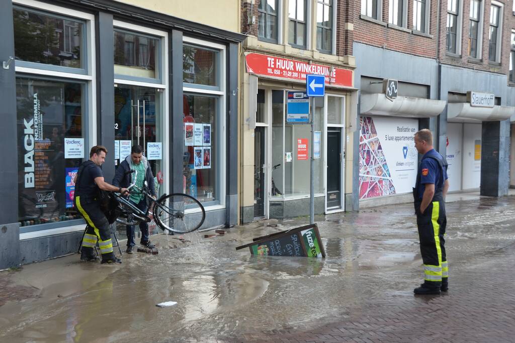 Winkelstraat blank na gesprongen waterleiding