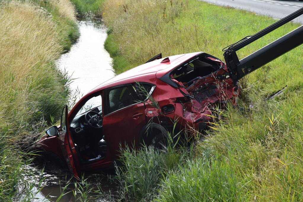 Coolblue-bestelbus knalt personenauto de sloot in