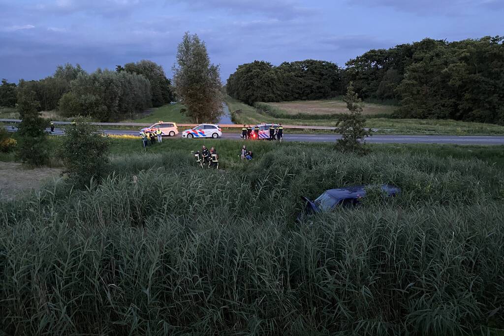 Bestelbus vliegt over de vangrail belandt in riet
