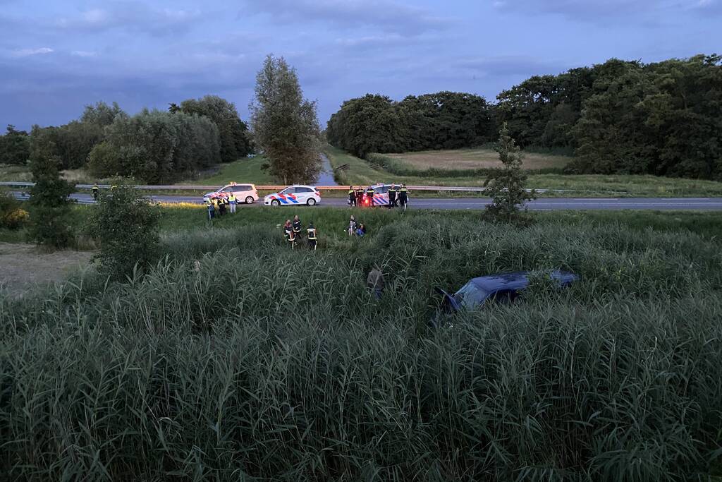 Bestelbus vliegt over de vangrail belandt in riet