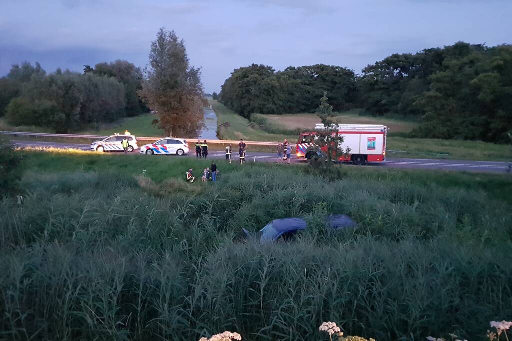 Bestelbus vliegt over de vangrail belandt in riet