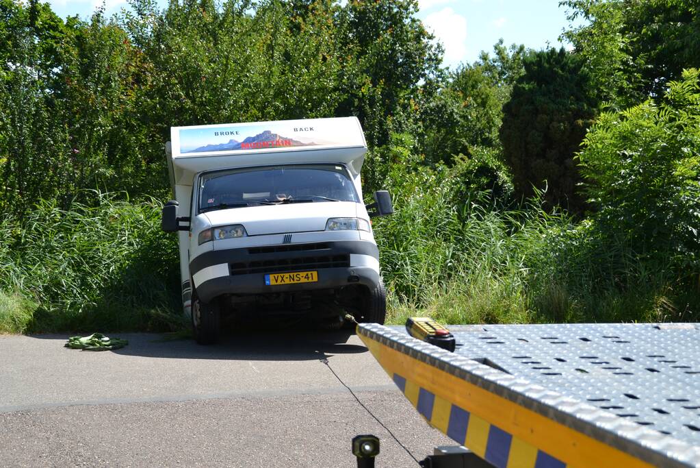Camper rijdt achteruit de sloot in