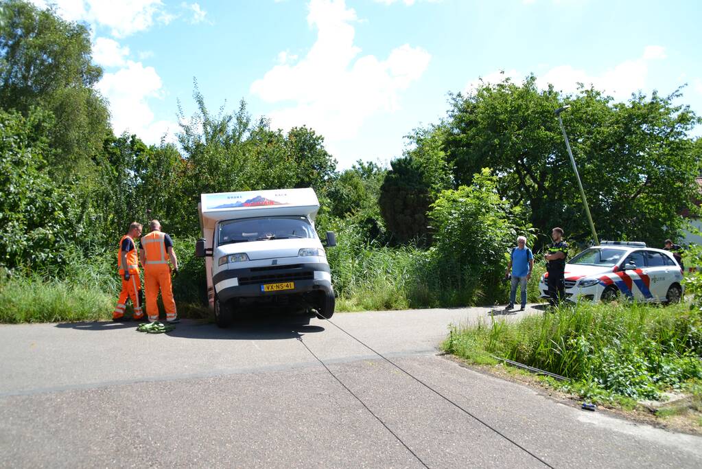 Camper rijdt achteruit de sloot in