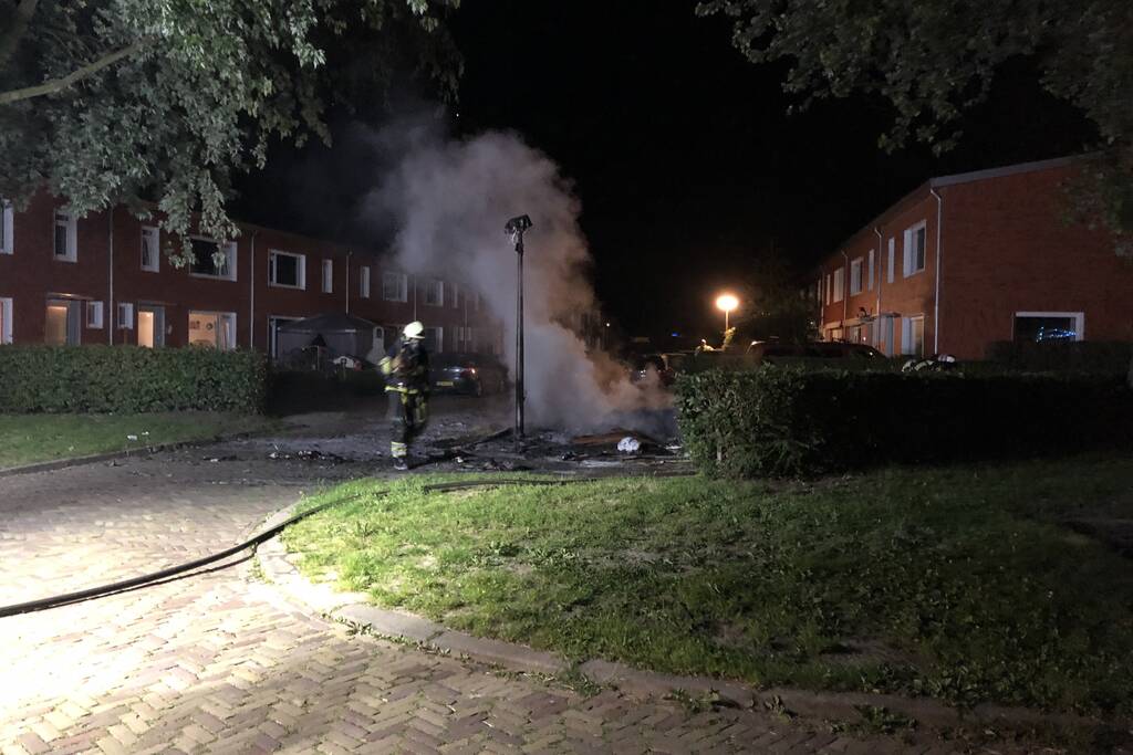 Stapel grofvuil laat lantaarnpaal branden