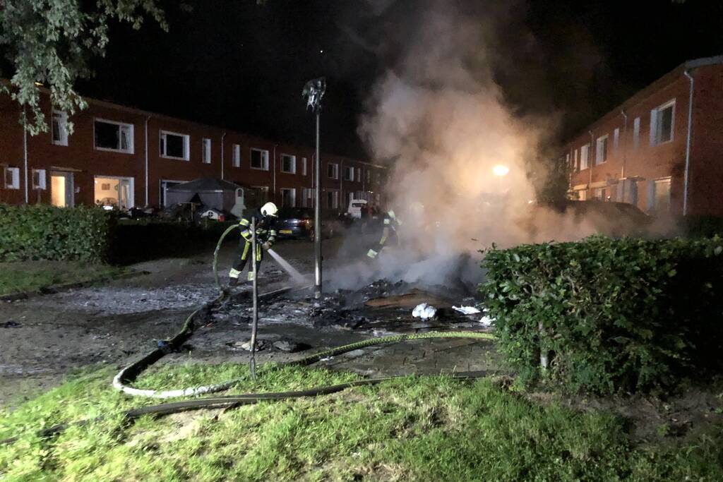 Stapel grofvuil laat lantaarnpaal branden
