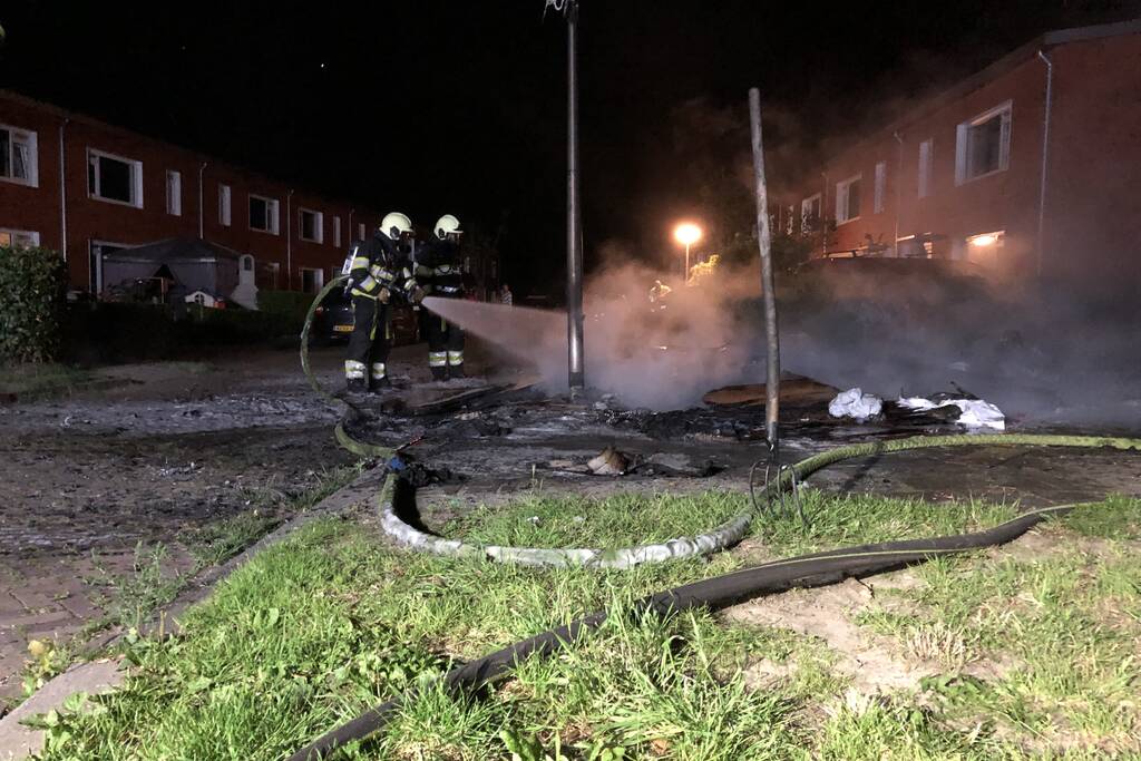 Stapel grofvuil laat lantaarnpaal branden