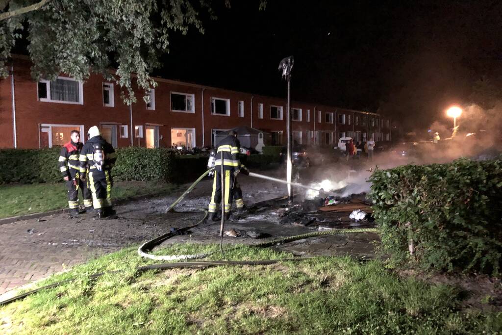 Stapel grofvuil laat lantaarnpaal branden