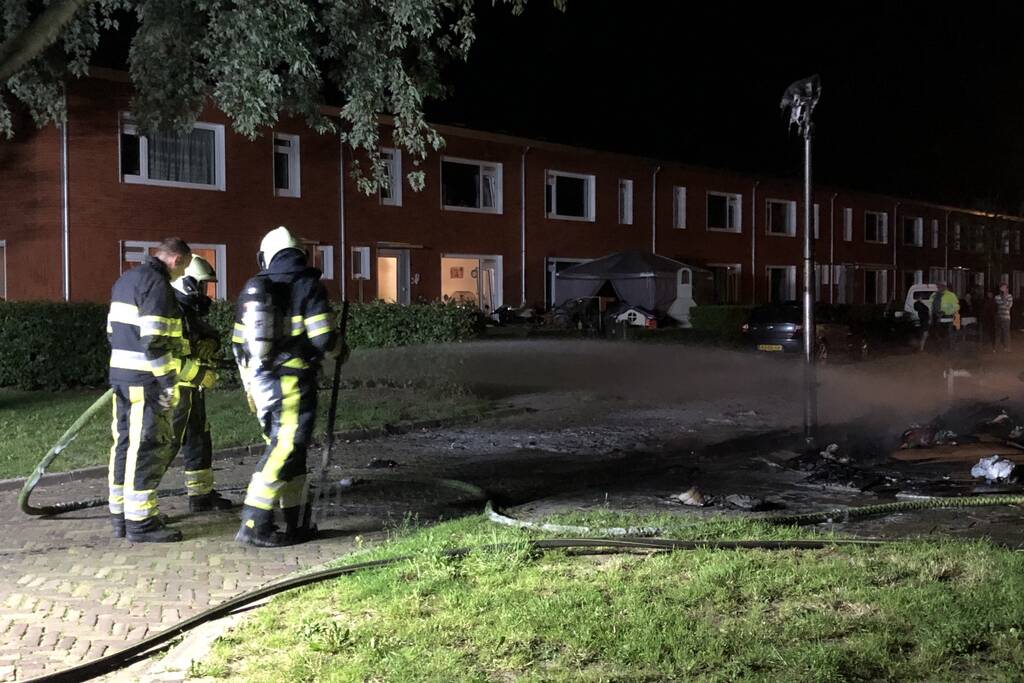 Stapel grofvuil laat lantaarnpaal branden