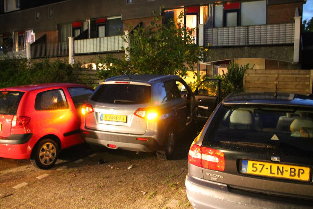 Auto botst op twee geparkeerde auto's en belandt in achtertuin