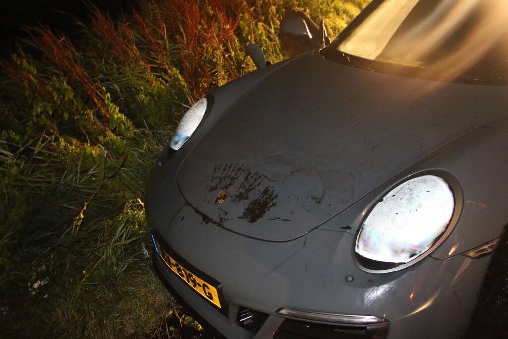 Peperdure Porsche belandt in de vaart na ontwijken van een dier