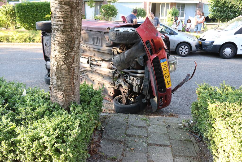 Bestuurder raakt onwel, botst op geparkeerde auto en belandt op zijn kant