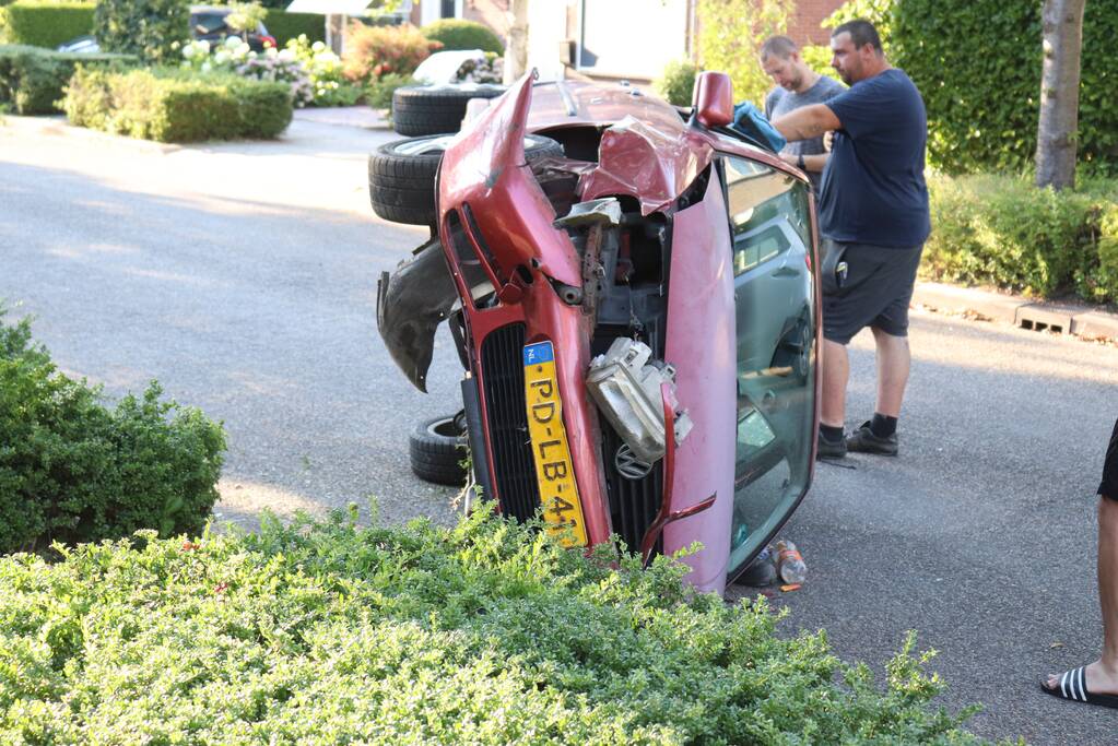 Bestuurder raakt onwel, botst op geparkeerde auto en belandt op zijn kant
