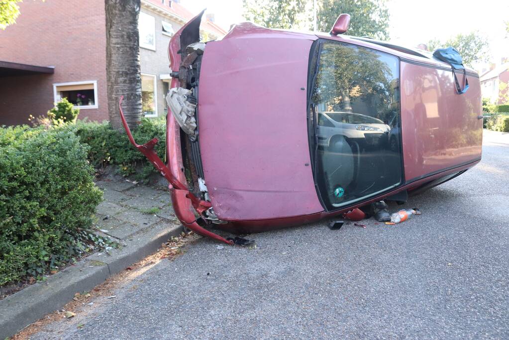 Bestuurder raakt onwel, botst op geparkeerde auto en belandt op zijn kant