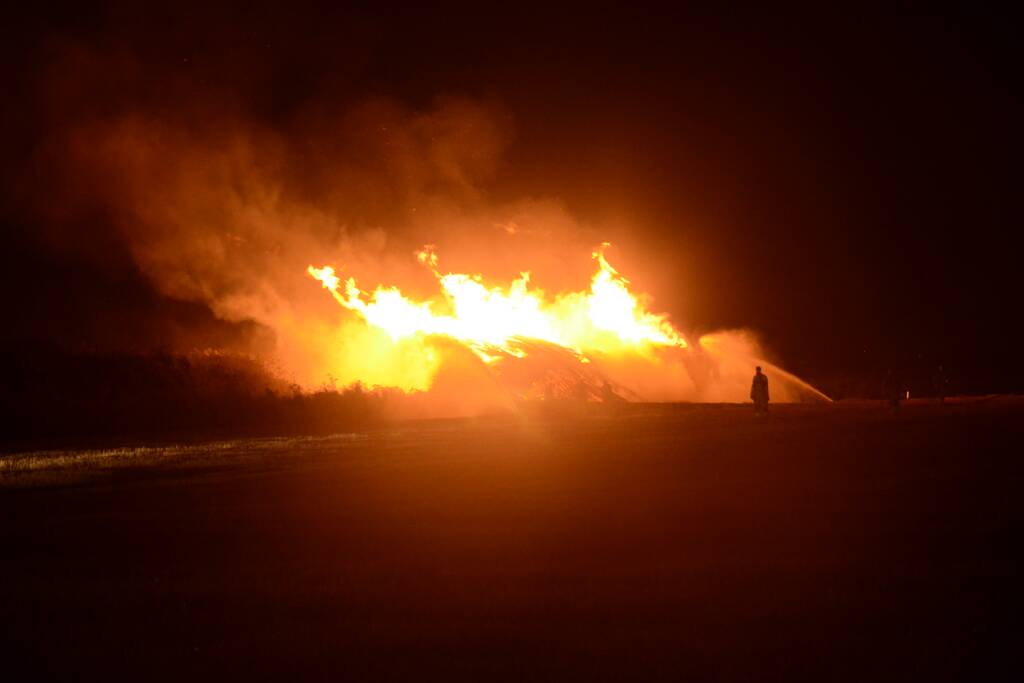 Grote stapel met wilgenhout vliegt in brand