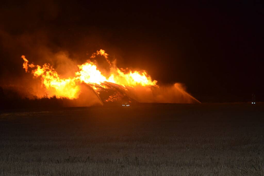 Grote stapel met wilgenhout vliegt in brand