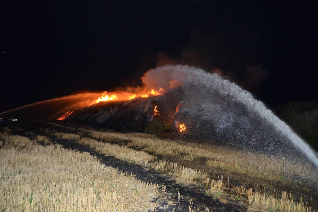 Grote stapel met wilgenhout vliegt in brand