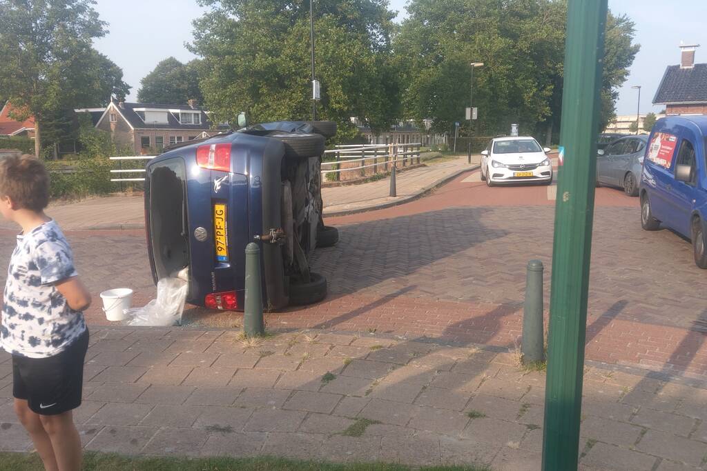 Auto op zijn kant na verkeersongeval