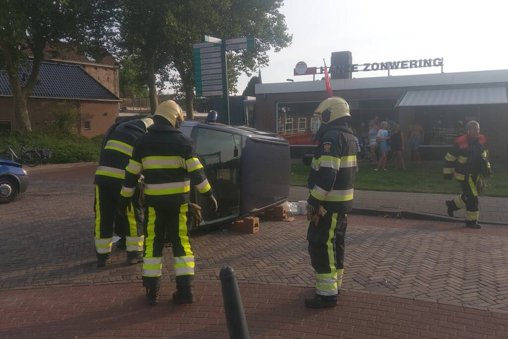 Auto op zijn kant na verkeersongeval