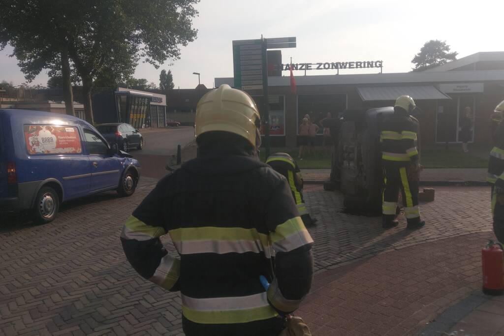 Auto op zijn kant na verkeersongeval