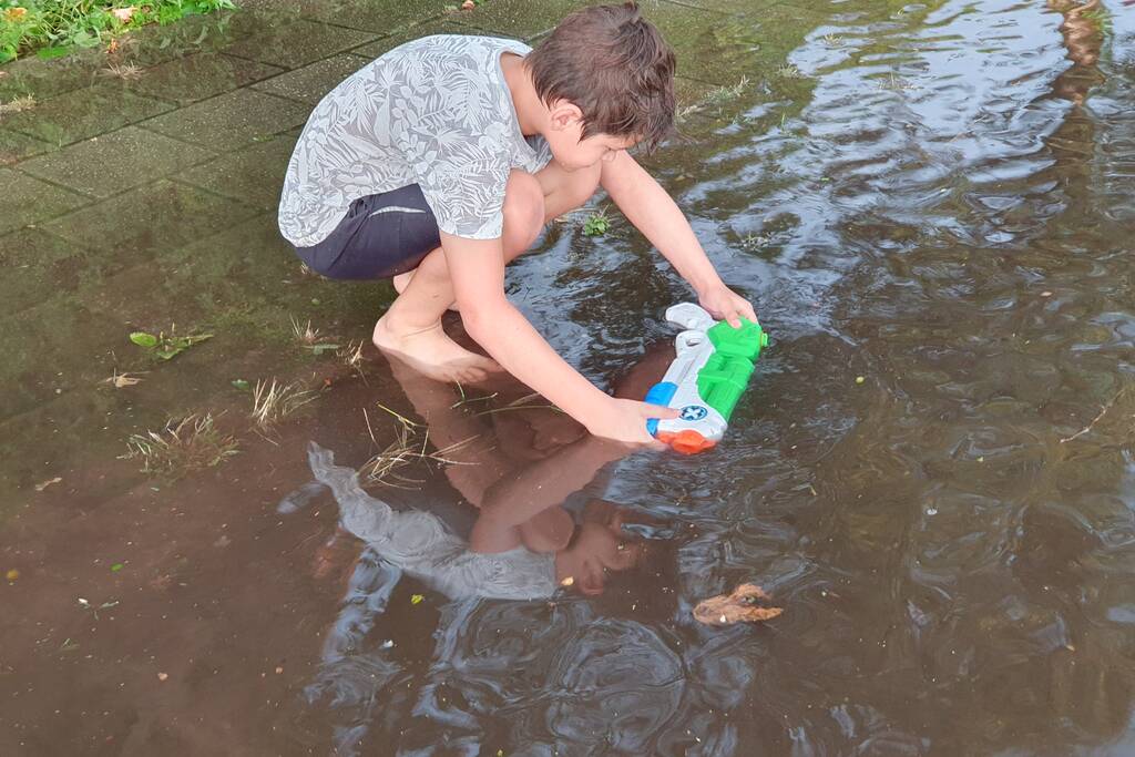 Jeugd vermaakt zich in ondergelopen straat