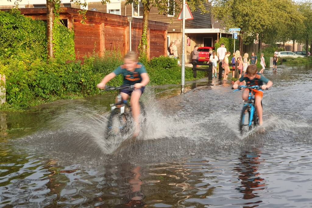 Jeugd vermaakt zich in ondergelopen straat