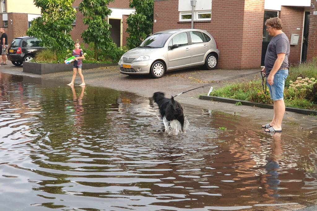 Jeugd vermaakt zich in ondergelopen straat